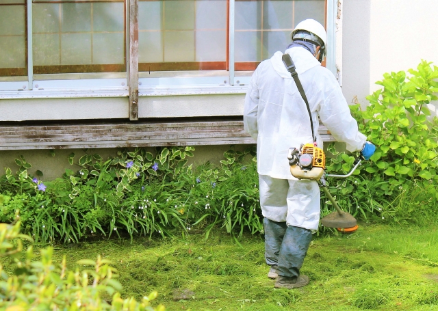 新潟市の住宅街でバッテリー式刈払機を使って早朝に作業している様子