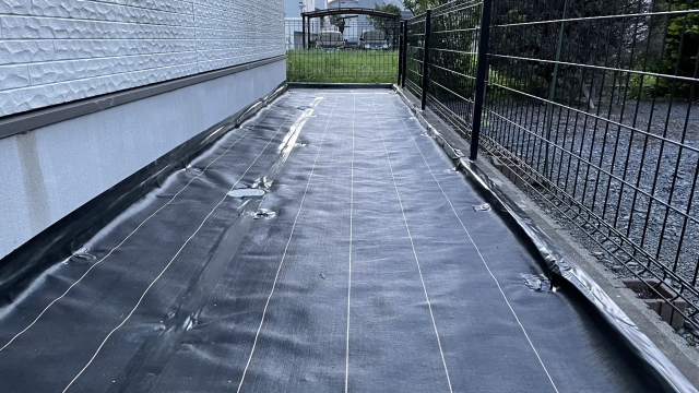 新潟市の住宅で防草シートを敷設している様子